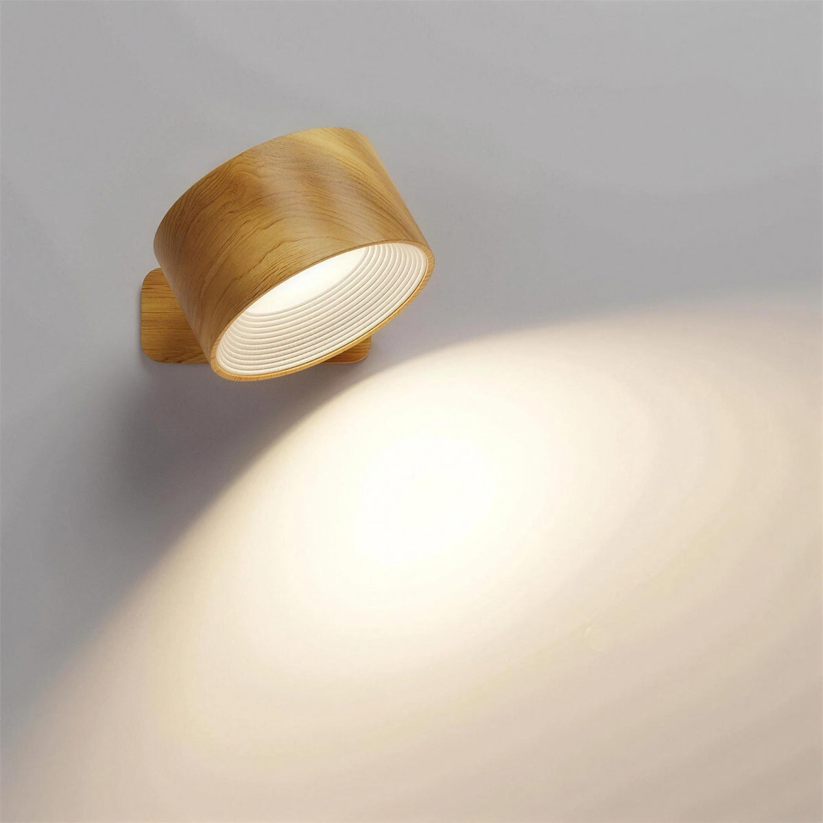 Nook cordless wall lamp in wood, switched on, on a plain wall