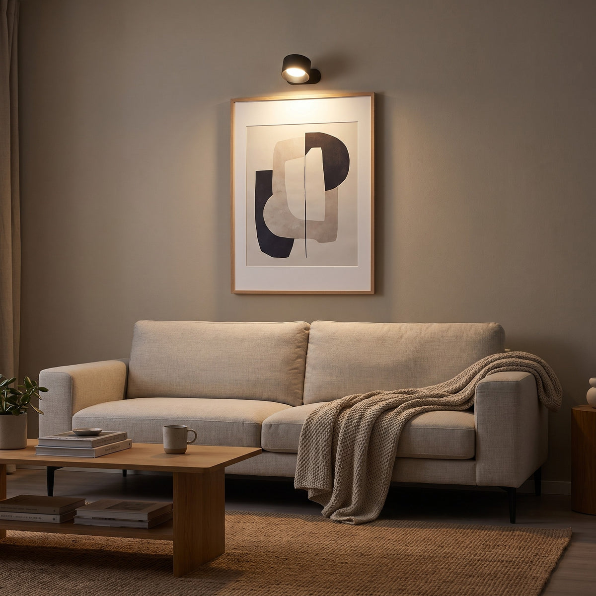 Black Nook lamp lighting a framed print above a sofa