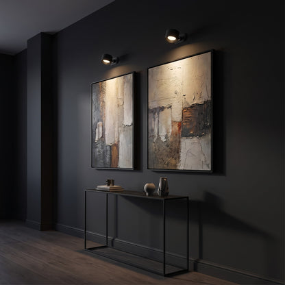 Two black Nook lamps lighting artwork in a dark corridor