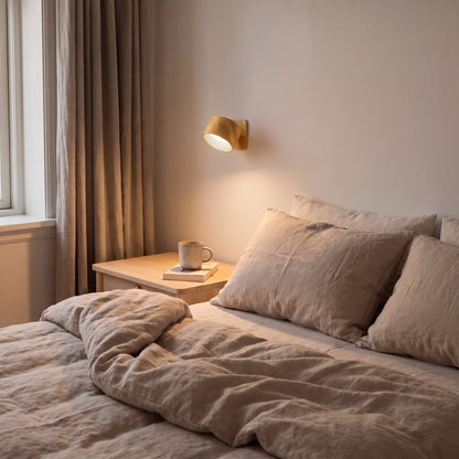 Wood Nook lamp beside a bed, lighting a nightstand