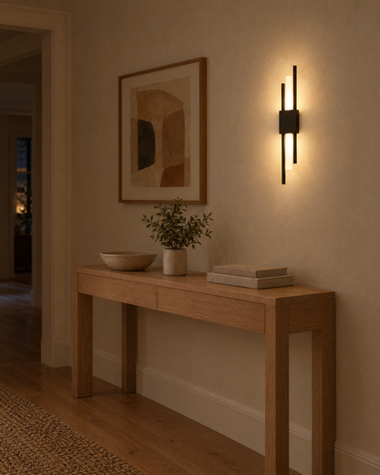 Black Nook Duo Sconce lit on a hallway wall above a console table