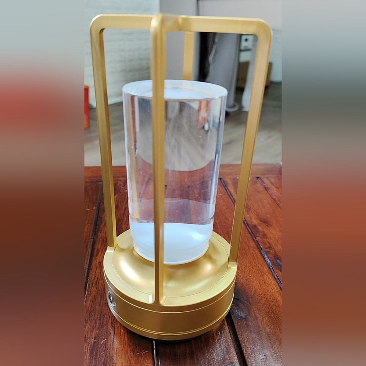Nook Glow Lantern in gold on a wooden table, switched off