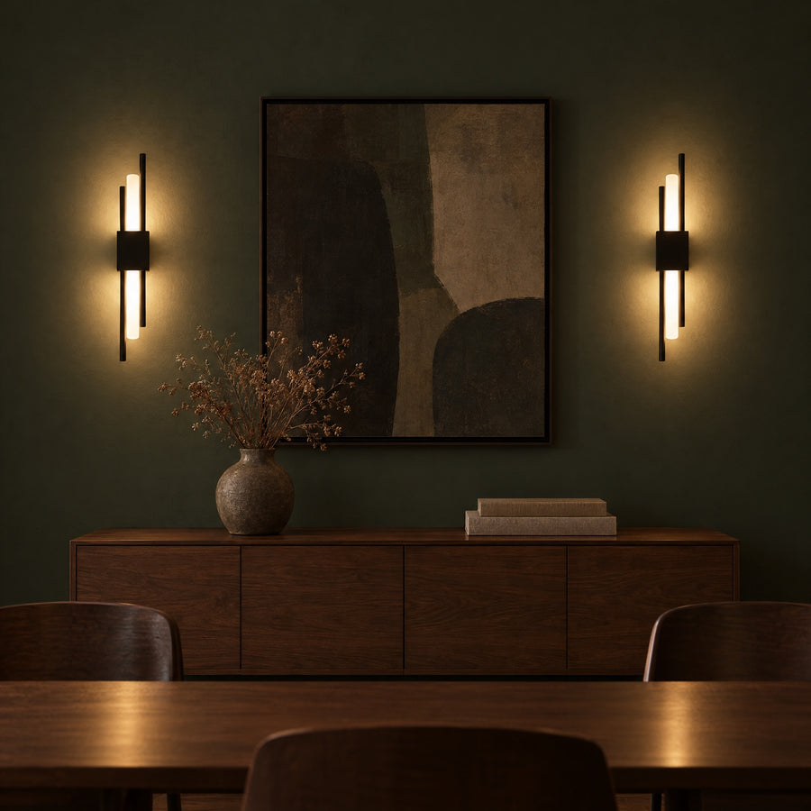 Illustration: A pair of black sconces on a dark green wall, above a sideboard.