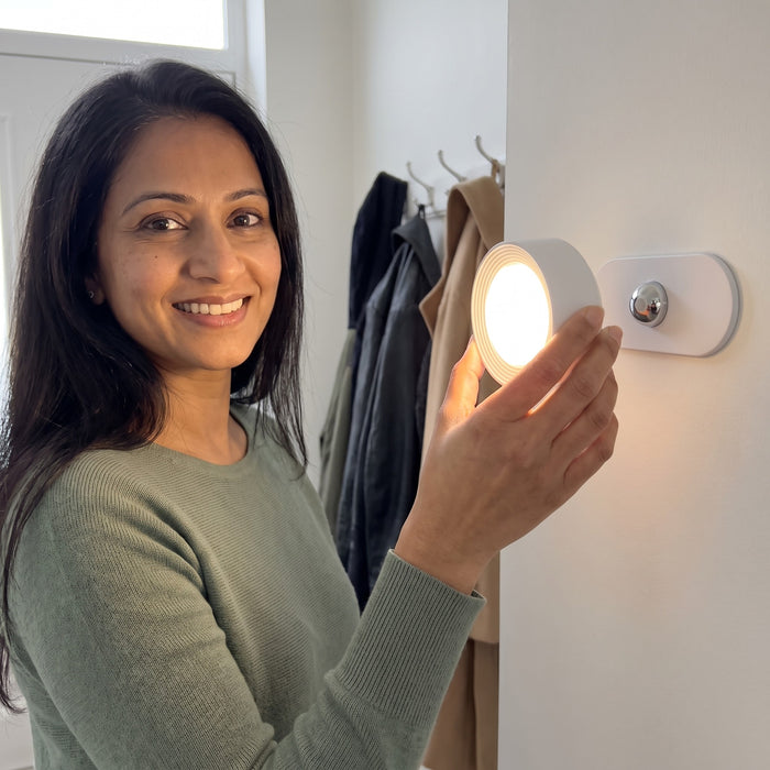 Woman snapping the white Nook lamp onto its wall mount