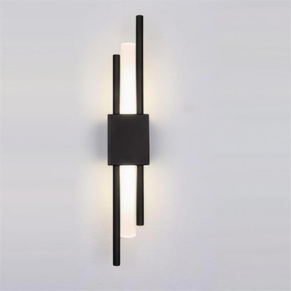 Nook Duo Sconce in black, lit on a grey wall