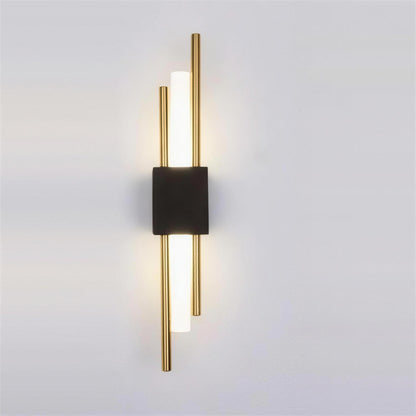 Nook Duo Sconce, black and gold, lit on a grey wall