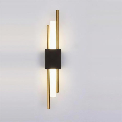 Nook Duo Sconce, black and gold, lit on a grey wall
